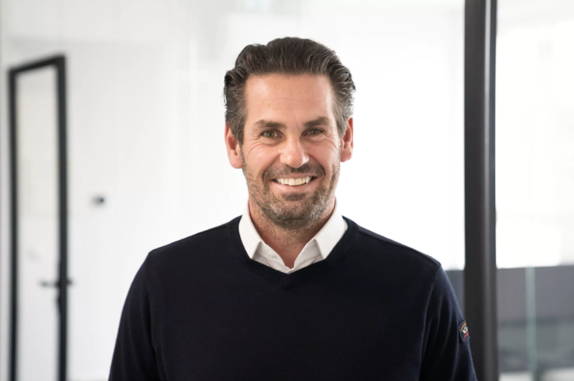 Markus Suppan mit schwarzem Pullover und weißem Hemd lacht in die Kamera