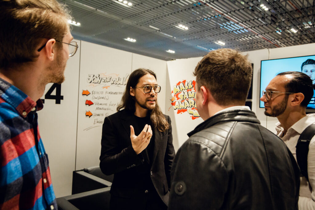 Sven Platte redet mit Personen auf einer Messe.