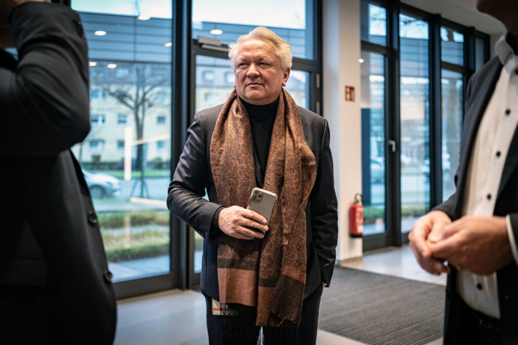 Armin Papperger mit Schal und einem Handy in der Hand