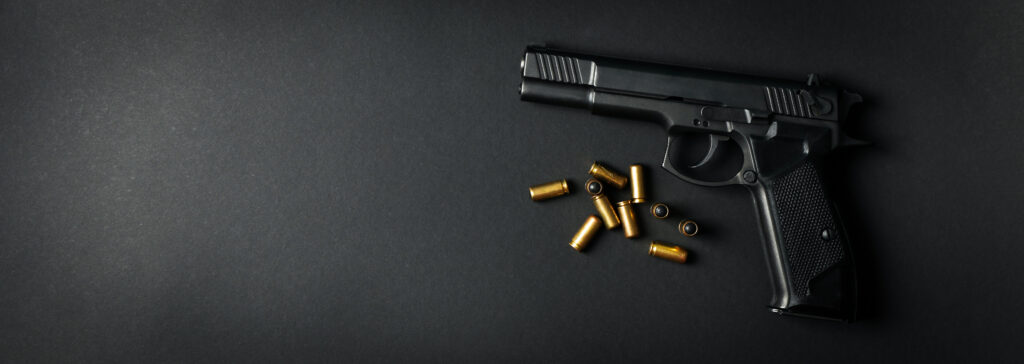 Waffe und Munition liegen auf einem schwarzen Hintergrund.