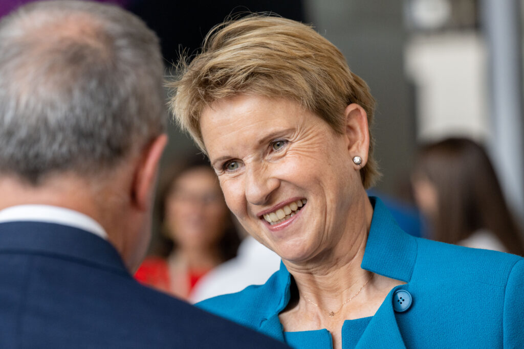 Susanne Kletten mit blauem Oberteil lächelt einem Mann zu