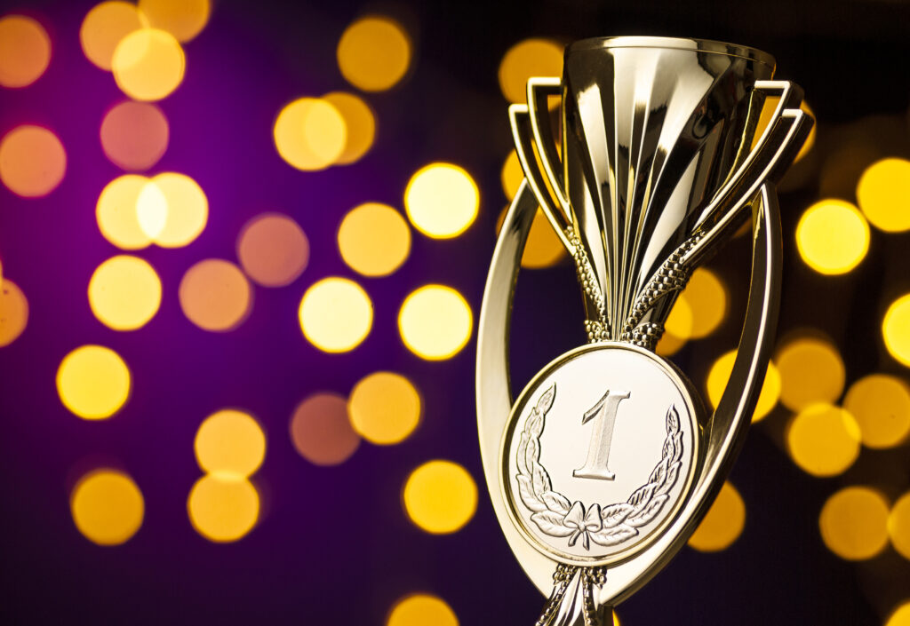 Goldener Pokal vor Hintergrund mit gelben und orangen Kreisen