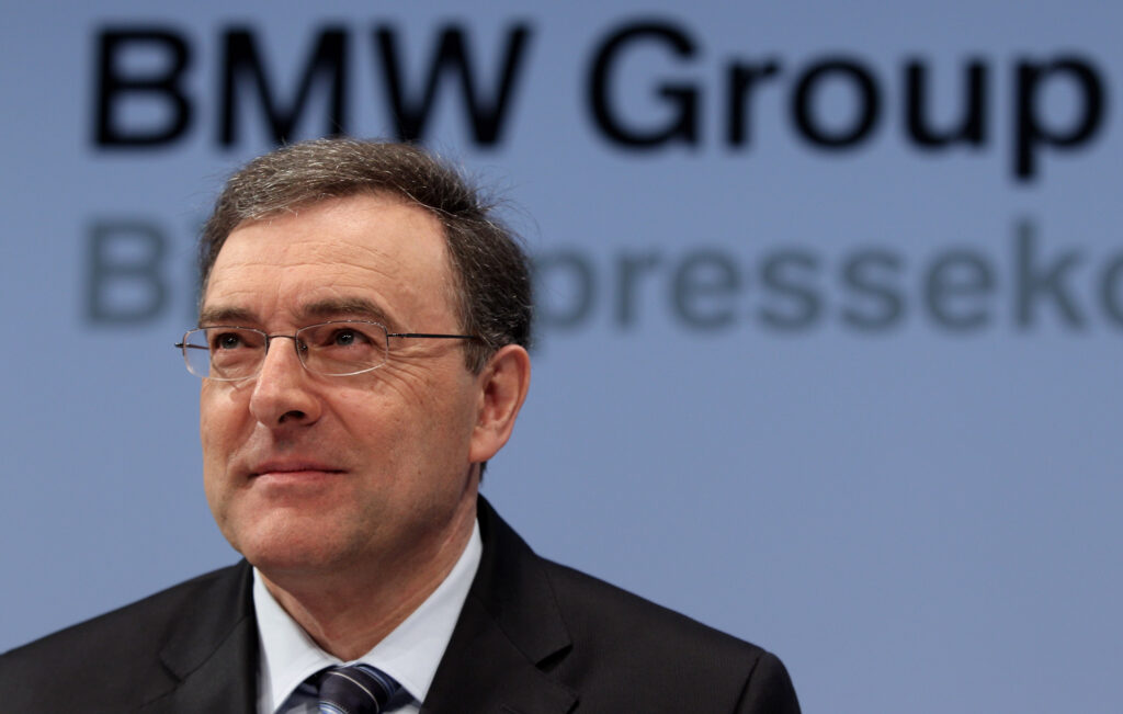 Norbert Reithofer im Portrait. Dahinter das Logo der BMW Group