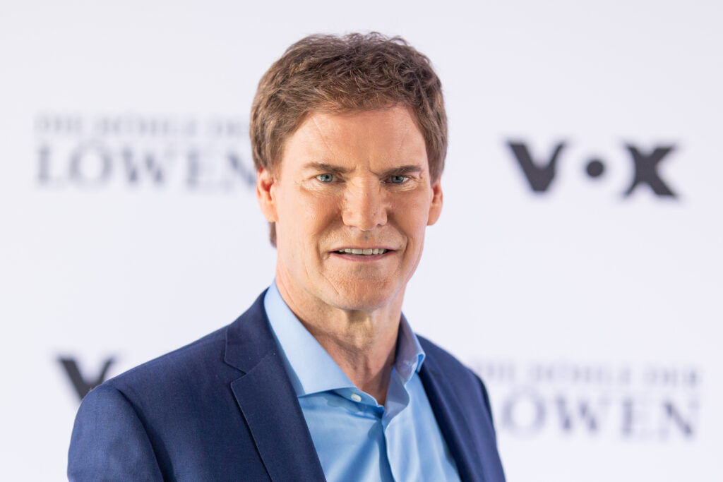 Carsten Maschmeyer, Gründer des AWD steht vor einem Werbeplakat auf dem man VOX erkennen kann