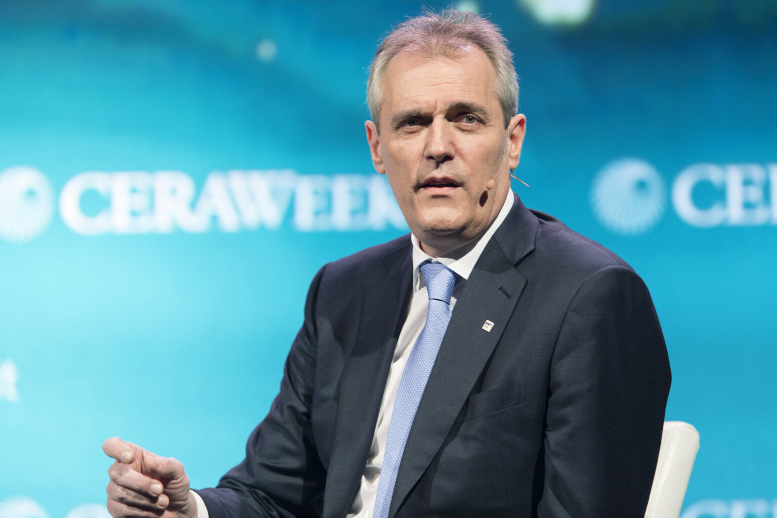Rainer Seele trägt einen dunklen Anzug und Krawatte und blickt direkt in die Kamera