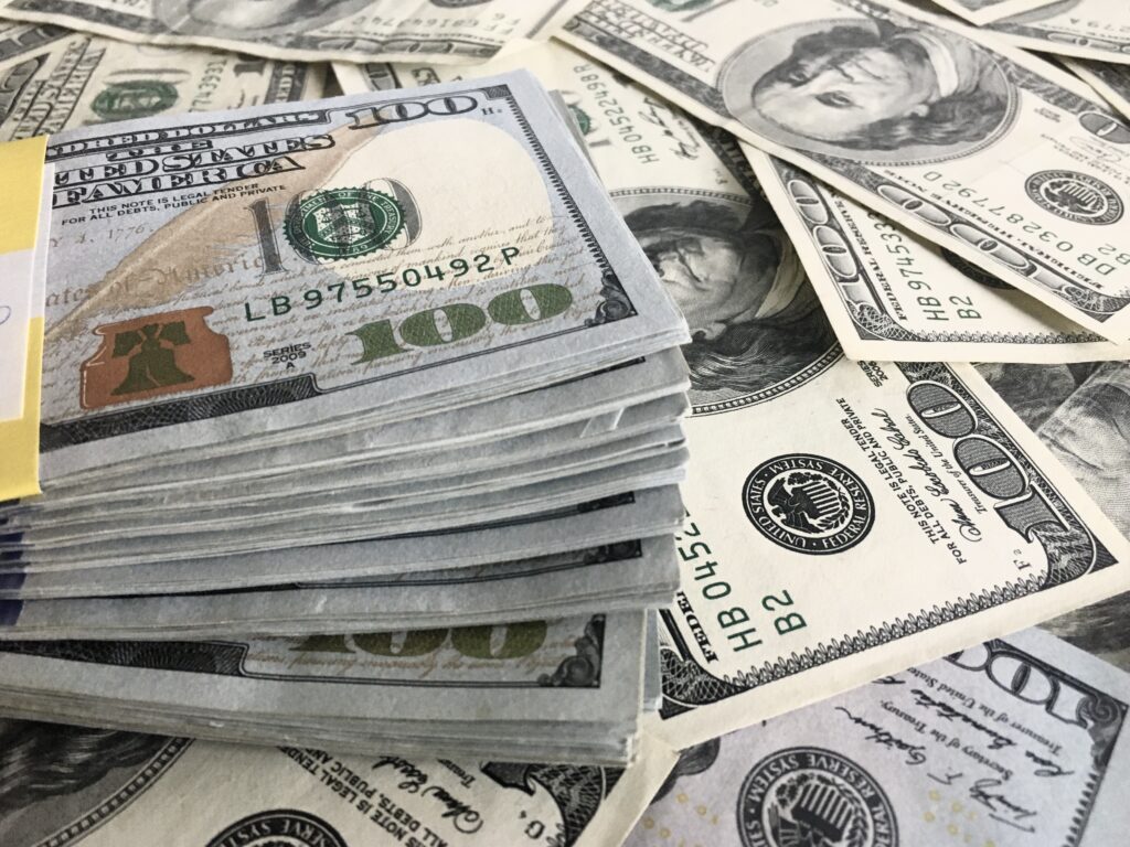 Viele Dollar Scheine und ein Büdel von Dollarscheinen 