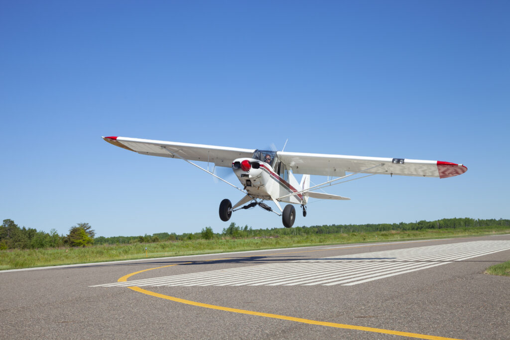 Reinhold Würth Kleines Sportflugzeug landet auf einer Landebahn