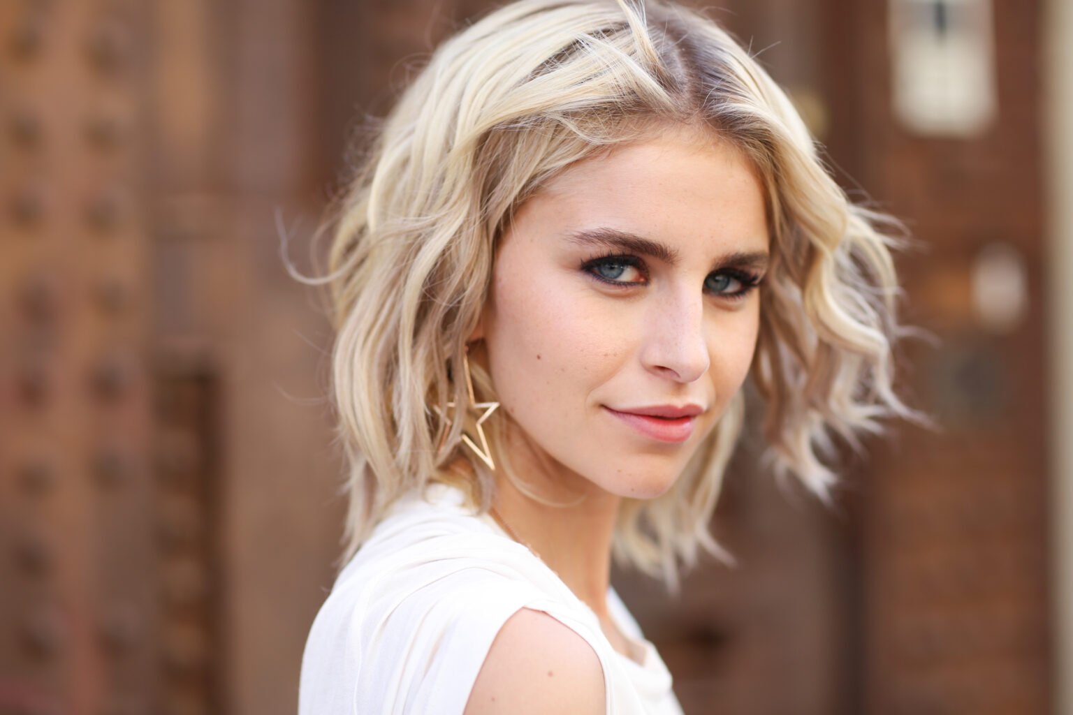 Caro Daur mit blonden Haaren und weißem Oberteil lächelt in die Kamera