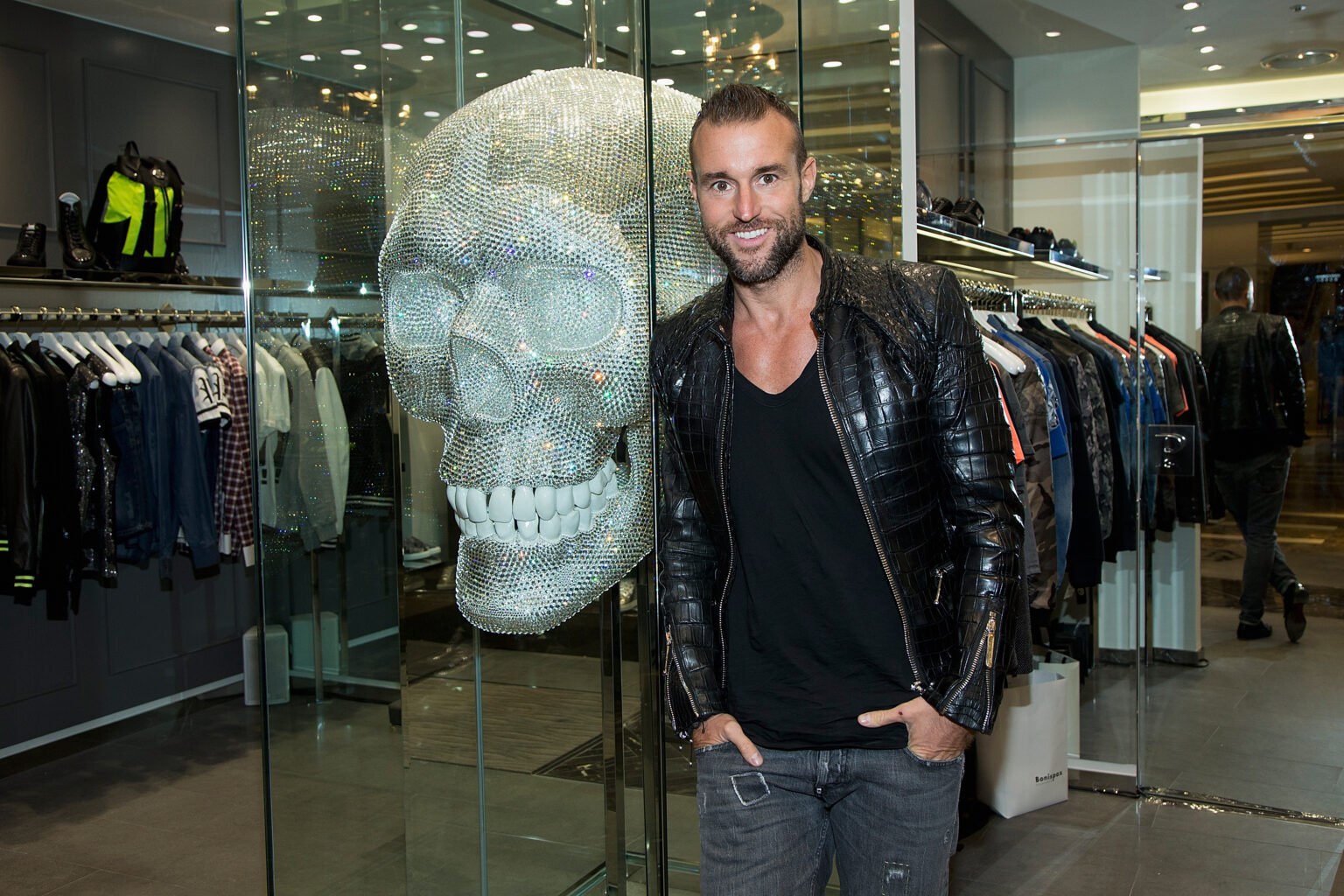Philipp Plein posiert vor seiner Mode und einem großen Totenkopf
