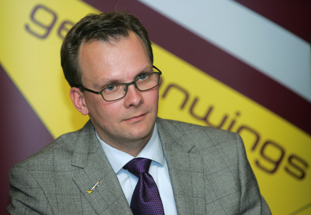 Andreas Biewirth mit kariertem Sakko und Brille blickt neben der Kamera vorbei