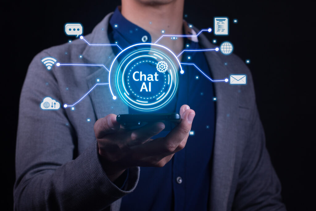 Ein Mann mit grauem Sakko und blauem Hemd hält ein Handy von dem aus virtuell Chat AI mit einige Symbolen dargestellt ist
