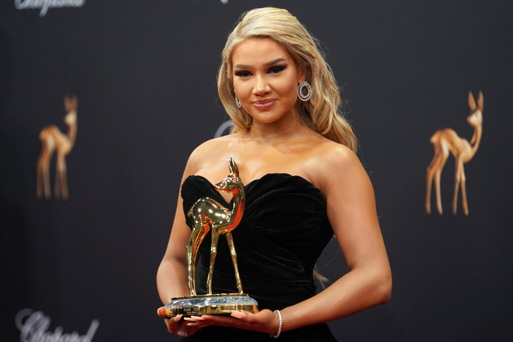 Shirin David trägt ein schulterfreies schwarzes Kleid und hält einen goldenen Bambi in ihren Händen