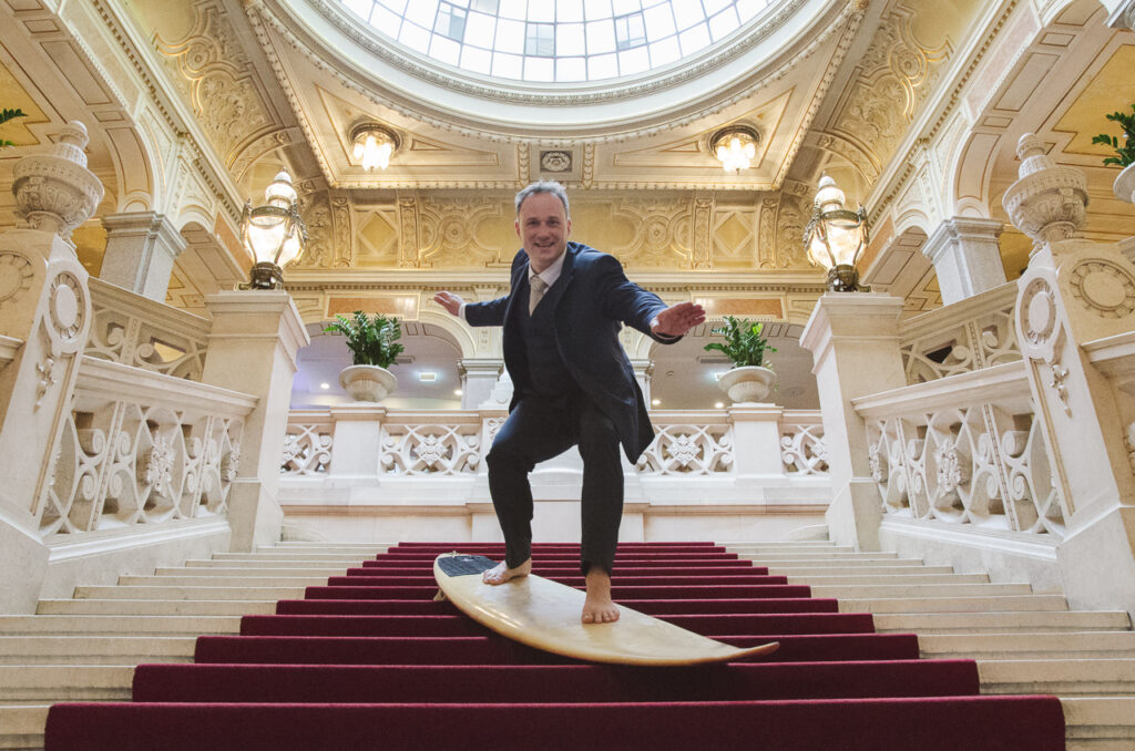 Mario Weissensteiner steht auf Surfbrett auf der Treppe der Grazer Oper