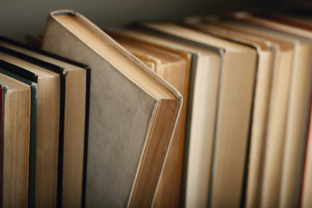 Eine Reihe von Büchern in Nahaufnahme. Ein Buch ist herausgeschoben