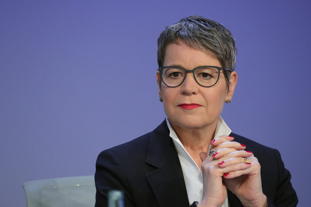 Susanne Menne trägt eine Brille und hält die Hände verschränkt