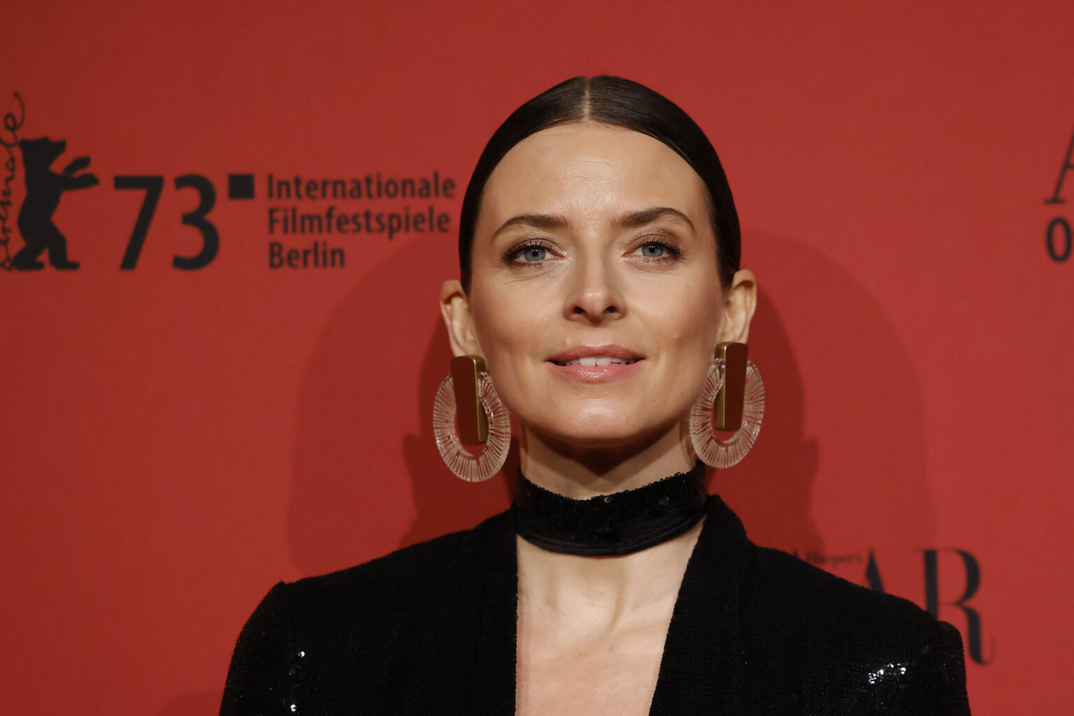 Eva Padberg vor einem roten Hintergrund blickt in die Kamera