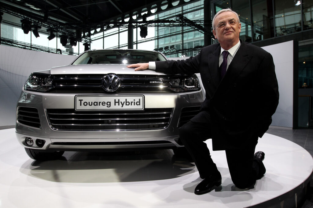 Martin Winterkorn kniet vor einem VW Toureg