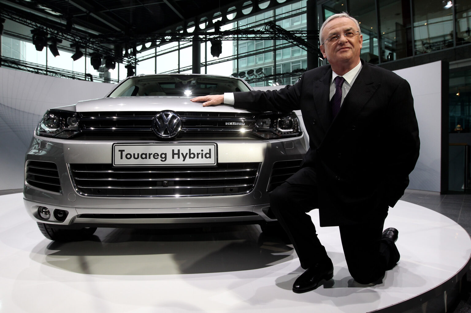 Martin Winterkorn kniet vor einem VW Toureg