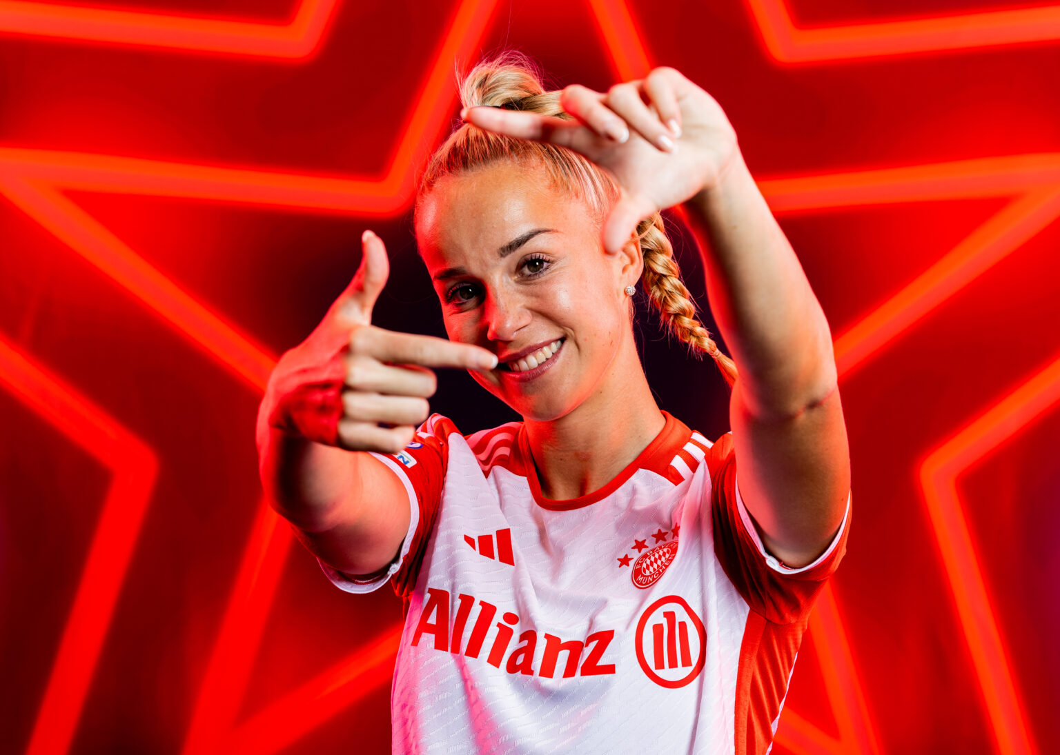 Giulia Gwinn mit rotem Fußballdress hält beide Hände in die Kamera