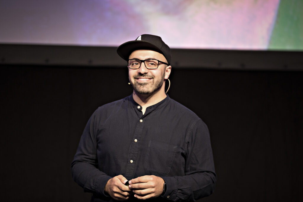 Ali Mahlodji steht auf einer Bühne