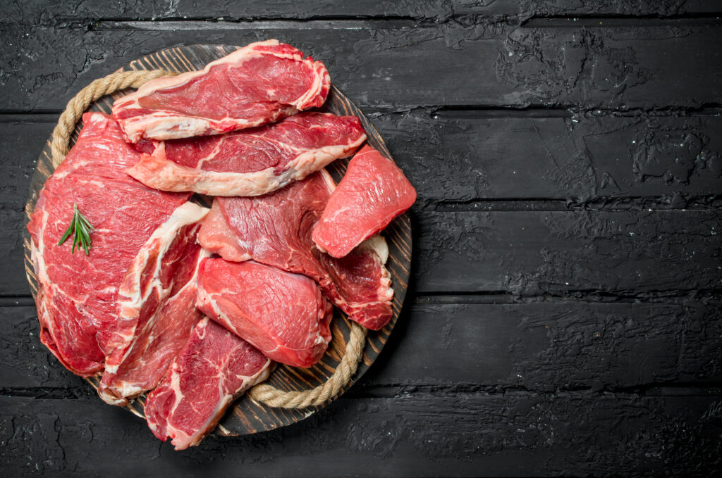 Clemens Tönnies Schweinefleisch roh in Nahaufnahme vor einem schwarzen Hintergrund
