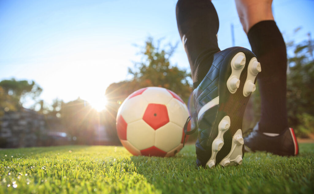 Fuß einer Fußballerin und ein weiß-roter Fußball
