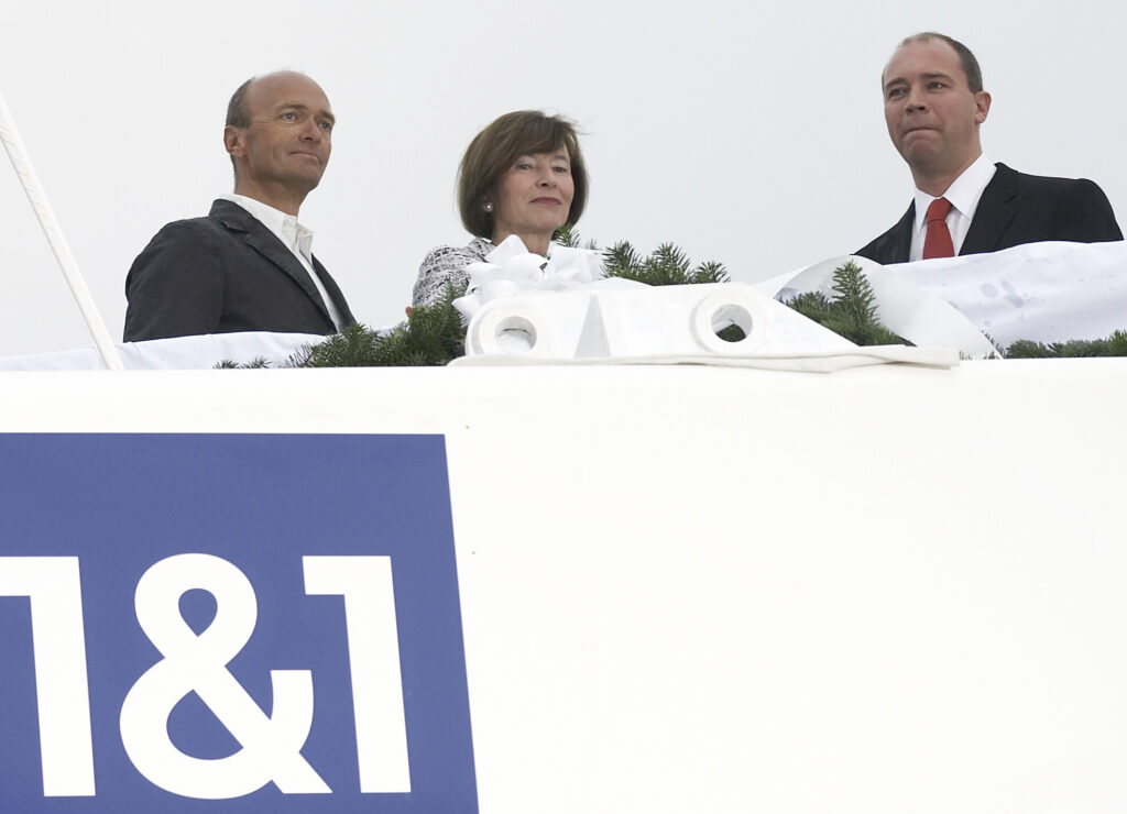Ralph Dommermuth steht neben zwei anderen Personen
