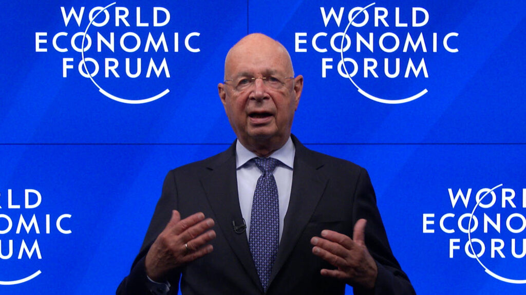 Klaus Schwab vor dem Plakat von World Economic Forum