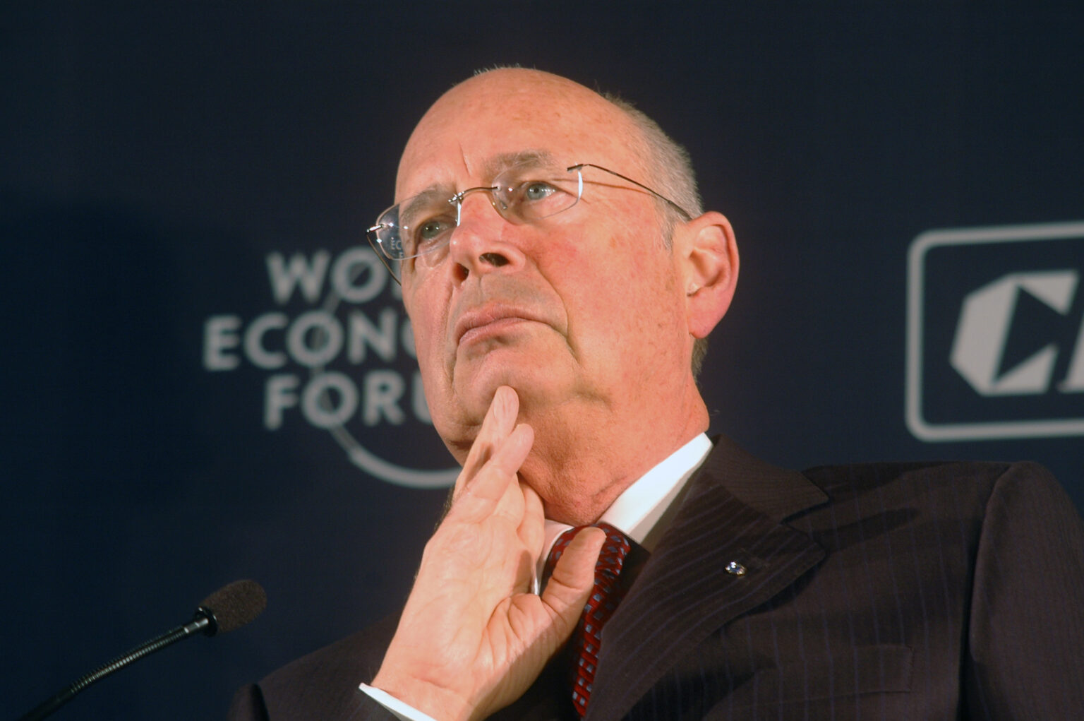 Klaus Schwab hält eine Hand auf sein Kinn
