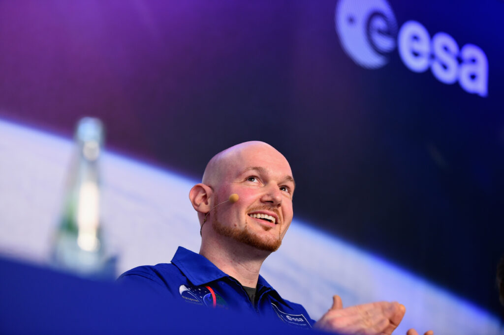 Alexander Gerst mit Head-Set in Nahaufnahme lacht und klatscht mit den Händen