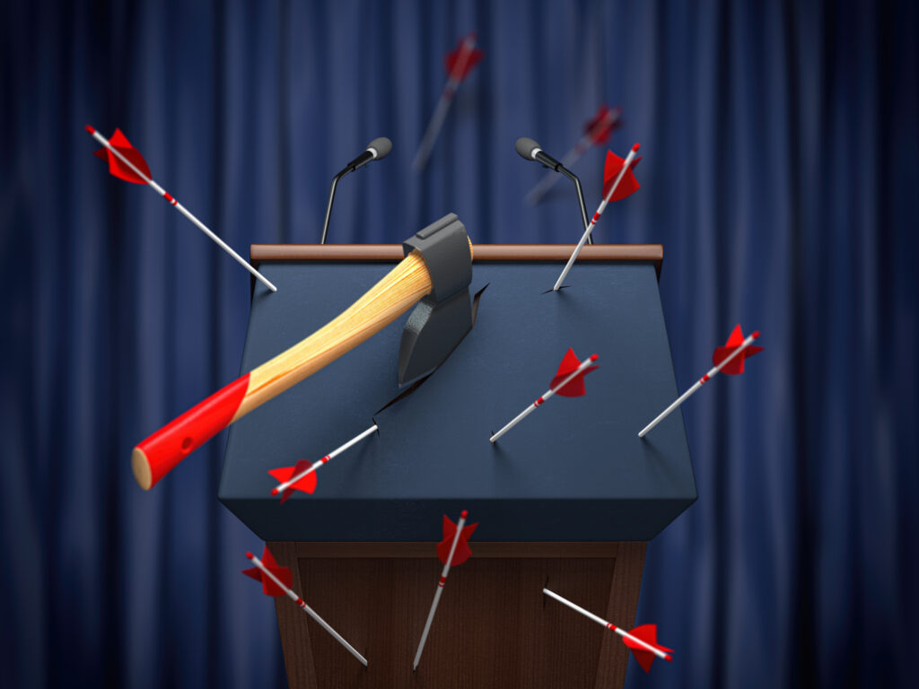 Rednerpult indem viele Pfeile und eine Axt steckt