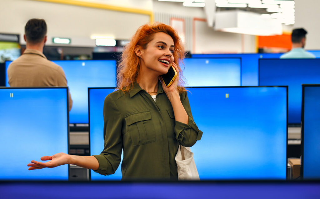 Bau mit Handy steht vor Bildschirmen