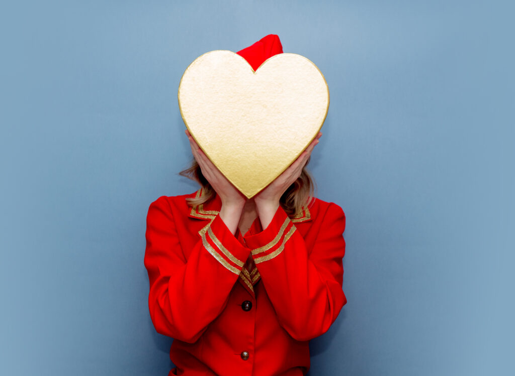 Goldenes Herz wird vor ein Frauengesicht gehalten